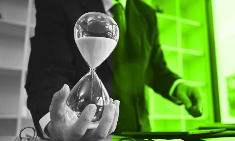 Bir çalışma masasında düzenli notlar, takvim ve kum saati; zamanı verimli kullanmayı, planlamayı ve iş hayatında önceliklendirmeyi simgeleyen görsel.