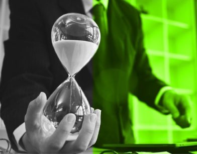 Bir çalışma masasında düzenli notlar, takvim ve kum saati; zamanı verimli kullanmayı, planlamayı ve iş hayatında önceliklendirmeyi simgeleyen görsel.